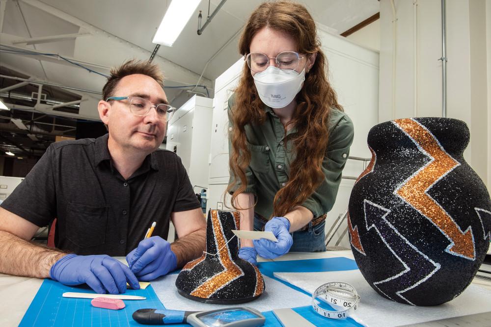 Emily Starck'14 and Jamie Kelly'96 examine a contemporary ceramic piece.